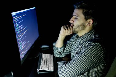 Yazılım geliştirici bilgisayarda karanlık ev ofis