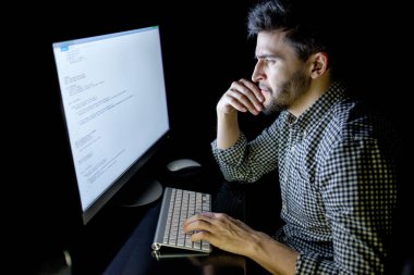 Yazılım geliştirici bilgisayarda karanlık ev ofis