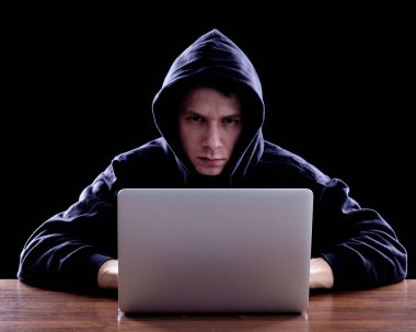 Karanlık bir defter önünde oturan hoody hacker