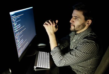 Yazılım geliştirici bilgisayarda karanlık ev ofis