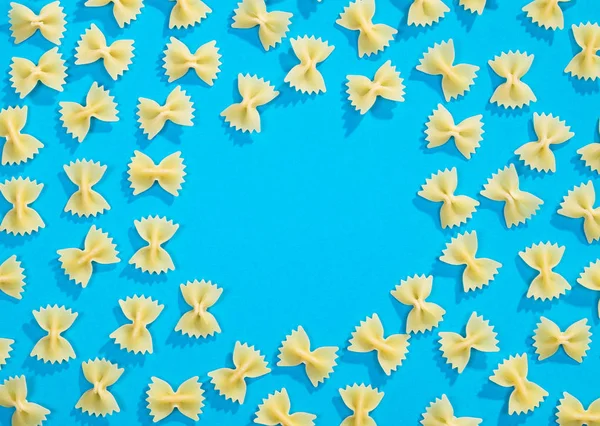 Frame from wheat pasta on blue background