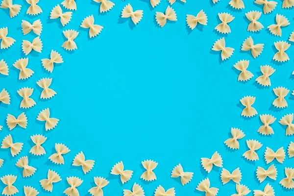 Frame from wheat pasta on blue background