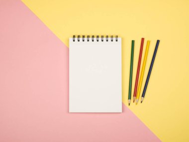 Renkli kalemler ile boş defter sayfasının Üstten Görünüm