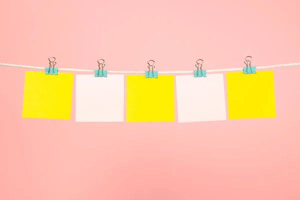 Notas de papel amarillo y rosa en blanco en la cuerda — Foto de Stock