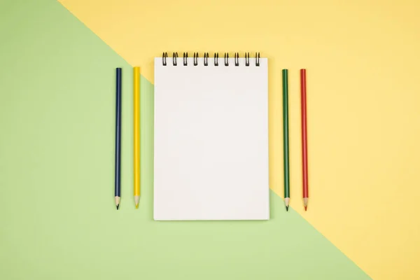 Vista superior de la página del cuaderno en blanco con lápices de colores — Foto de Stock