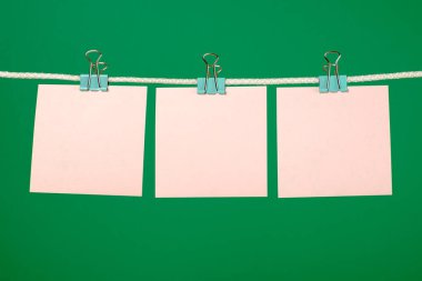 İpte asılı boş pembe kağıt sayfalarının