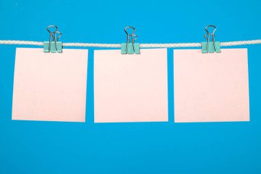 İpte asılı boş pembe kağıt sayfalarının