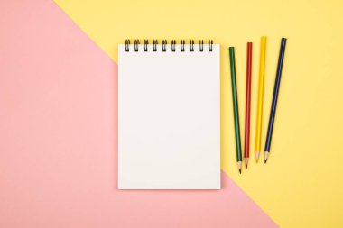 Renkli kalemler ile boş defter sayfasının Üstten Görünüm