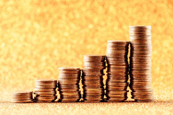 Stacks of copper coins on golden background