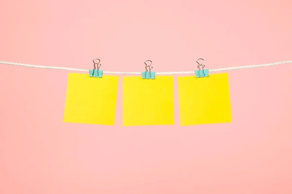 Notas de papel amarillo en blanco colgando del tendedero — Foto de Stock