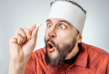 Tıbbi sargı hapları bir elinde tutan adam