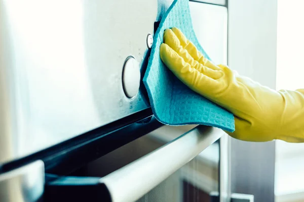 Die Hand des Mannes beim Putzen des Küchenofens — Stockfoto