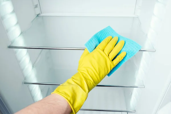 Man's hand washing refrigerator inside Stock Image