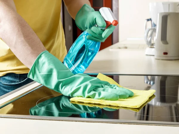 Uomo che pulisce il fornello in cucina — Foto Stock