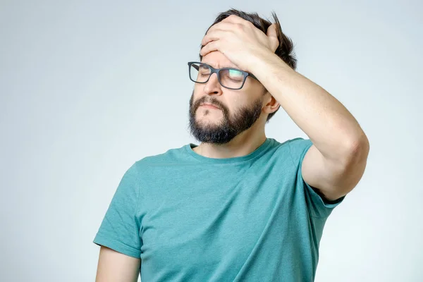 Пригнічений красивий бородатий чоловік торкається головного болю — стокове фото