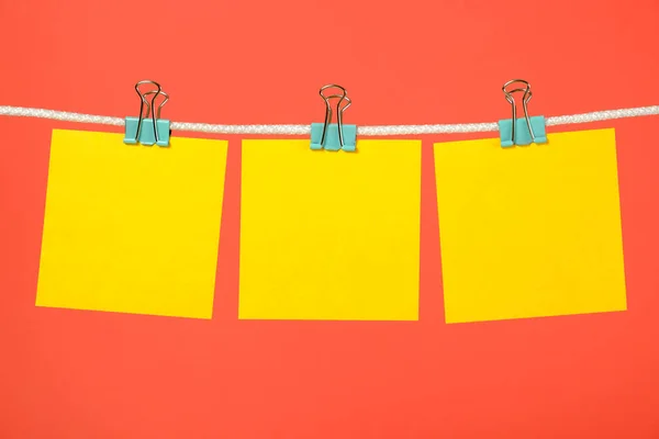 Notas de papel amarillo en blanco colgando del tendedero — Foto de Stock
