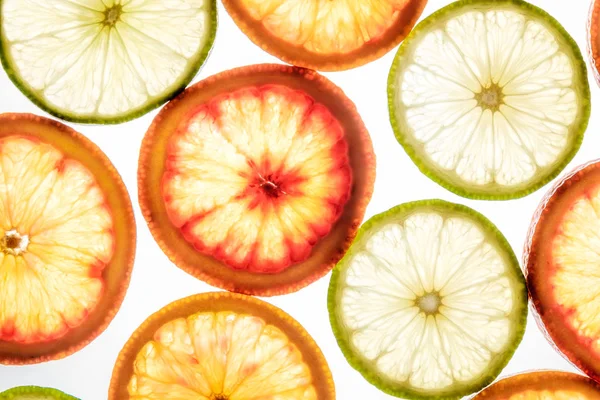 Tranches brillantes de citron vert et d'orange sur blanc — Photo