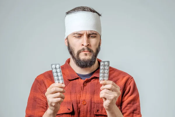 Triste hombre vendado herido con pastillas — Foto de Stock
