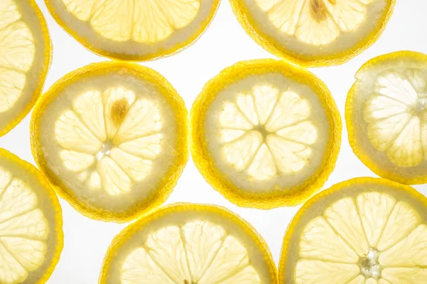 Яркие цитрусовые ломтики лимона на белом — стоковое фото