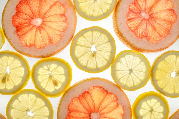 Ярко-сладкий грейпфрут и ломтики лимона на белом — стоковое фото