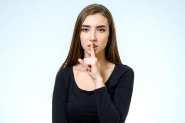 Sessizlik tutun! Dudaklarında parmak tutan güzel genç kadın