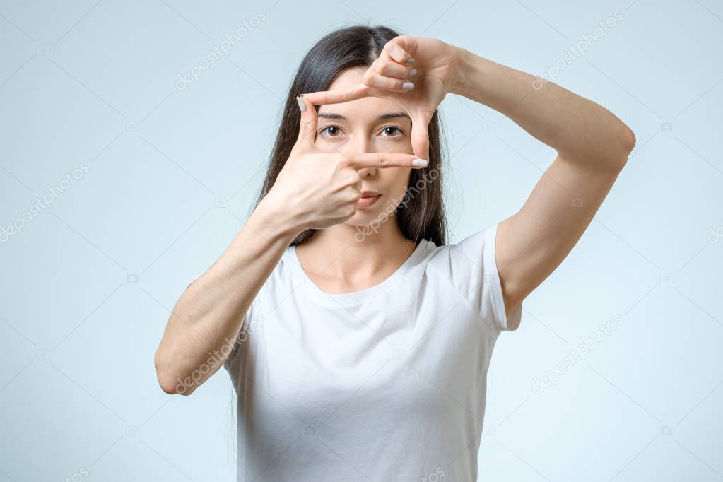 Attractive young woman using her hands to create a border