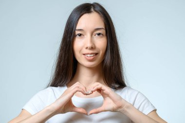 Genç güzel kız elleriyle bir kalp yapmak