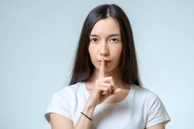 Sessizlik tutun! Dudaklarında parmak tutan güzel genç kadın