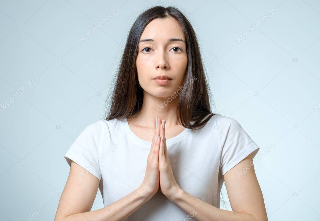 Closeup portrait of a young woman praying isolated