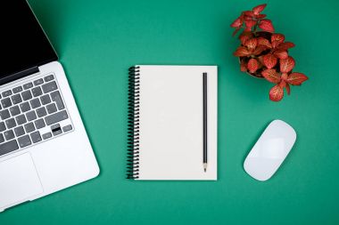 Dizüstü bilgisayar ve boş Not Defteri sayfası en az çalışma masası