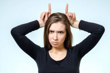 Boynuzları parmakları ile gösterilen kadın