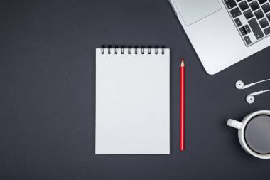 Dizüstü bilgisayar ve boş Not Defteri sayfası en az çalışma masası