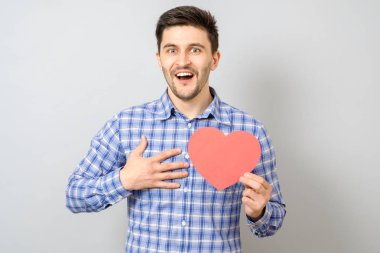 Kırmızı kağıt kalp tutan gülümseyen adam portresi