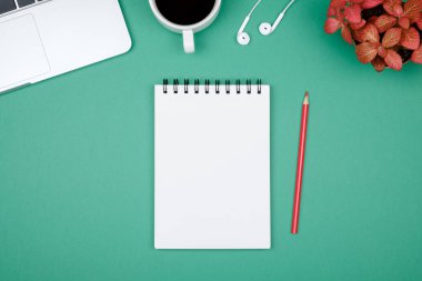 Dizüstü bilgisayar ve boş Not Defteri sayfası en az çalışma masası