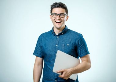 Dizüstü tutan tişörtlü kendine güvenen genç yakışıklı adam