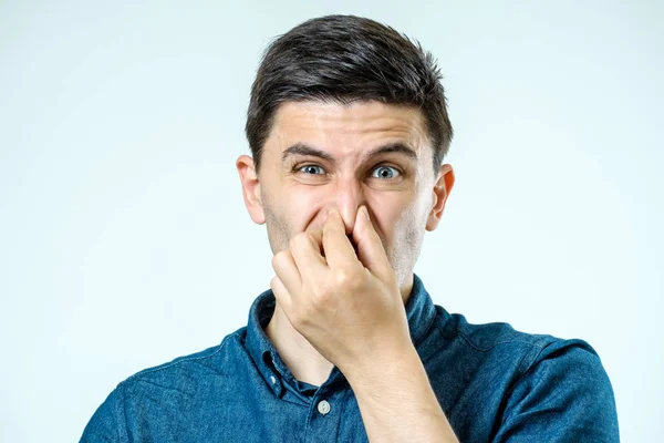 Mann hält Nase vor üblem Geruch — Stockfoto