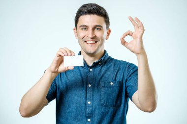 Genç adam boş kartvizit veya işareti gösterilen
