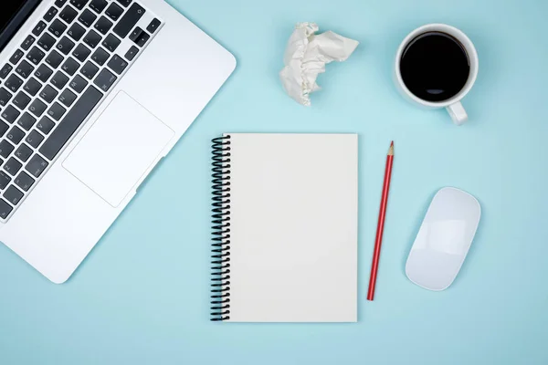 Minimal working desk with laptop and blank notepad page