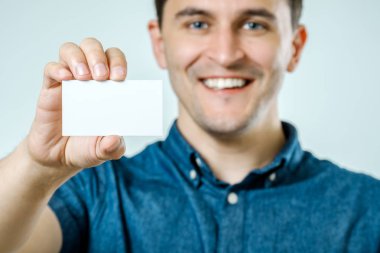 Genç adam boş kartvizit veya işareti gösterilen