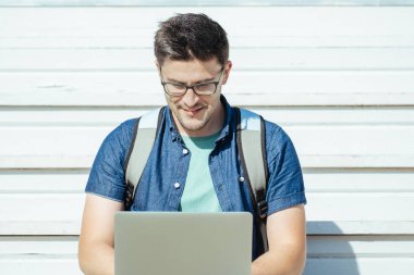 Ofis dışında dizüstü bilgisayar ile oturan adam