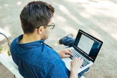 Ofis dışında dizüstü bilgisayar ile oturan adam