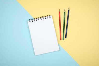 Renkli masa üzerinde açık sarmal boş defter Üstten Görünüm