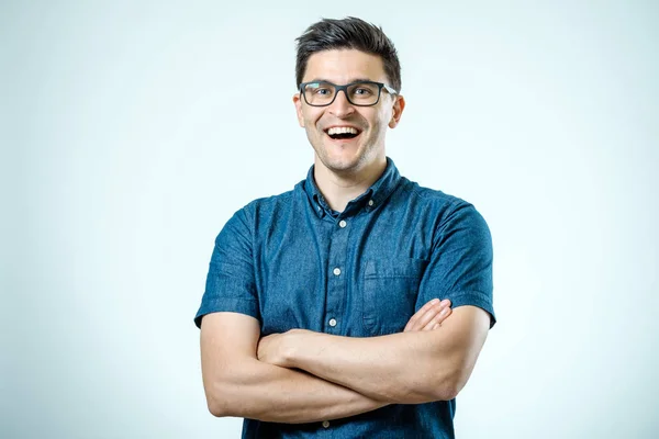 Studio shot of young man with crossed hands looking at the camer — Stock Photo, Image