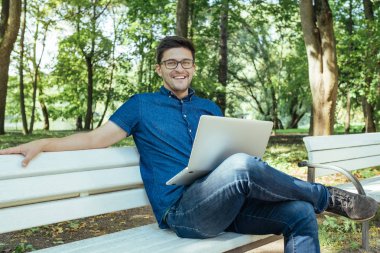 defter parkta oturan genç adam