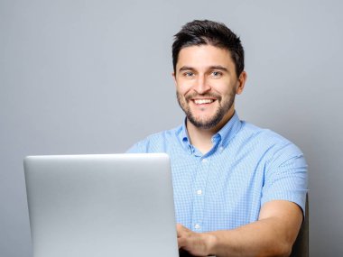 Mutlu adam gri izole dizüstü bilgisayar ile