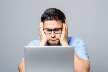 Laptop ile masada oturan dalgın hüzünlü adam