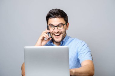 Mavi gömlek giymiş ve cep telefonundan konuşuyor yakışıklı adam