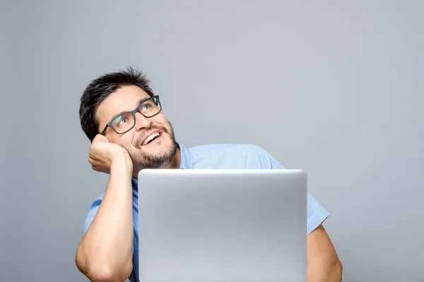 Imagen del hombre pensador vestido con camisa azul usando computadora portátil — Foto de Stock