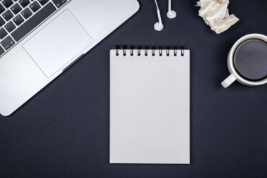 Dizüstü bilgisayar ve boş Not Defteri sayfası en az çalışma masası