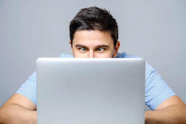 Portrait of shocked man sitting at the table with laptop — Stock Photo, Image